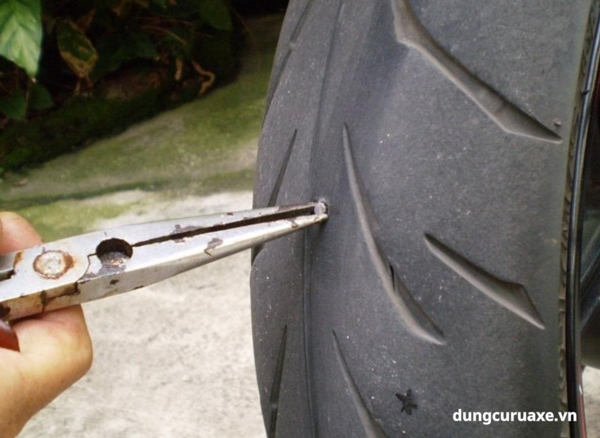 Dùng kìm rút dị vật ra khỏi lốp